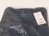 a black t - shirt wrapped in plastic on a white surface