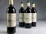 three bottles of red wine are lined up on a table
