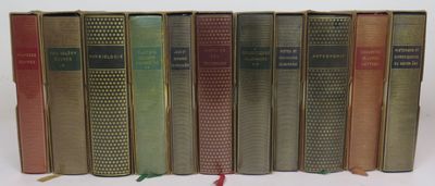 several books are lined up in a row on a white surface