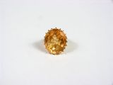 une bague sertie d'un saphir jaune sur un fond blanc