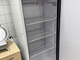 an empty refrigerator in the corner of a kitchen