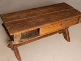 an old wooden table with a drawer on it