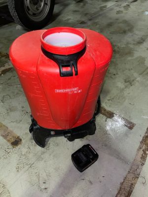 a red container sitting on the ground next to a black object