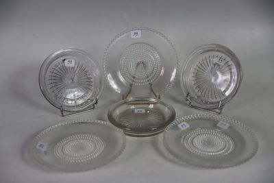 several glass plates and bowls are arranged on a white surface