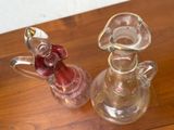 deux vases en verre posés sur une table et contenant des cerises
