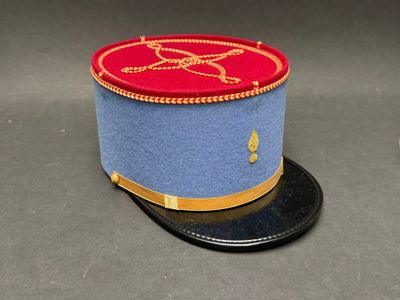 un chapeau bleu avec un bord rouge et un ruban doré