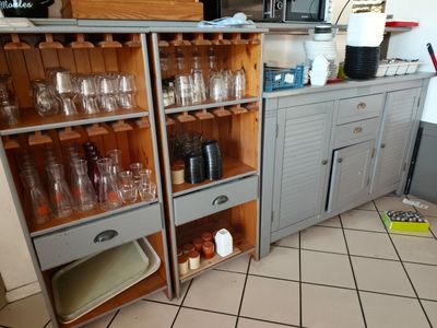 une cuisine avec beaucoup de bouteilles et de verres sur les étagères