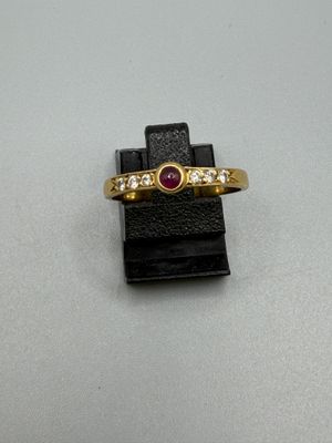 une image d'une bague en or avec une pierre en rubis