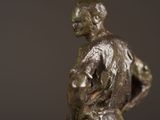 a bronze statue of a man with a bag on his back