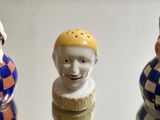 three figurines of different colors and sizes on a table