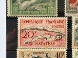 four different postages of different colors and designs on a black surface
