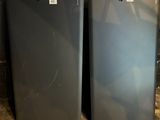 pair of two gray refrigerators sitting next to each other on a wooden floor