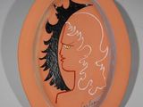 peinture représentant le visage d'une femme sur une assiette surmontée d'une couronne