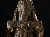 statue of a woman holding a cross on a black background