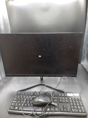 un écran d'ordinateur et un clavier posés sur une table