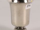 an antique silver cup with a label on the side