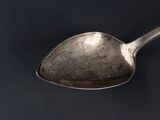 a spoon that is sitting on a black surface