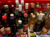 plusieurs bouteilles d'alcool dans un panier rouge posé sur une table