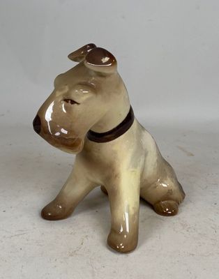 a small dog figurine sitting on a white surface