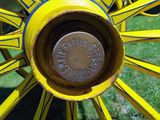 a close up of a yellow wagon wheel with a coin on it