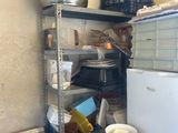 a small kitchen with a stove, microwave and other items on the shelves