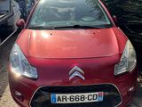 une Citrole rouge garée sur un parking à côté d'autres voitures