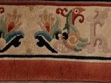 a close up of a rug with birds and flowers on it