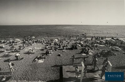 photo en noir et blanc de personnes sur une plage avec des parasols