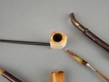 a lot of different types of smoking pipes on the table