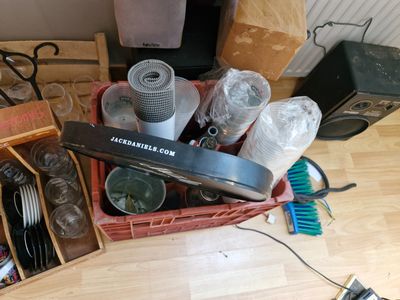 a basket full of silverware and other items on the floor