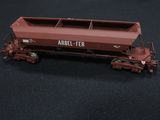 a red train car that is sitting on a black surface