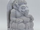 statue of an elephant holding a baby sitting on a rock