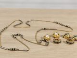 a necklace, earring, and bracelet set on a table