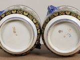 two blue and white vases sitting on a table