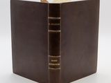 un gros plan sur un livre marron contenant trois autres livres