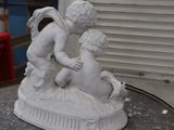 a statue of a boy and a girl playing with a bird