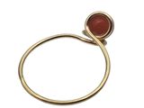 a close up of a gold ring with a red stone