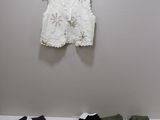 a white shirt hanging on a wall next to a pair of green pants