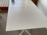 a white table that is sitting on the floor in front of a window