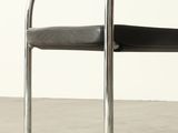 a black chair with a black seat on a concrete floor