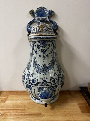 a blue and white vase sitting on a wooden table