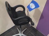 une chaise noire sur laquelle est posée une lumière bleue, dans une pièce