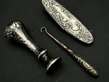 une cuillère en argent et un couteau posés sur une surface noire