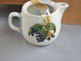a tea pot with a tea in it next to a box of cookies