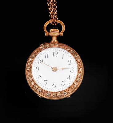 une montre de poche ancienne en or, munie d'une chaîne, sur fond noir