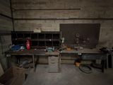 une photo d'un établi dans un garage, avec de nombreux outils