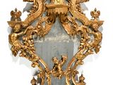 a mirror with a gold frame and a clock on it