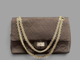 a close up of a brown purse with a chain around it