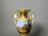 a vase with a painting on it on a table