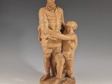 statue d'un homme tenant un enfant et un chien, posée sur un socle